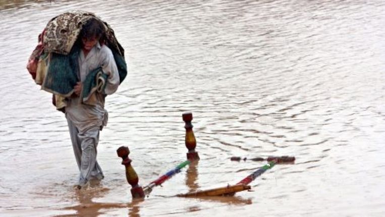 Een slachtoffer van de overstromingen in Pakistan baant zich een weg door het water. ANP Beeld 
