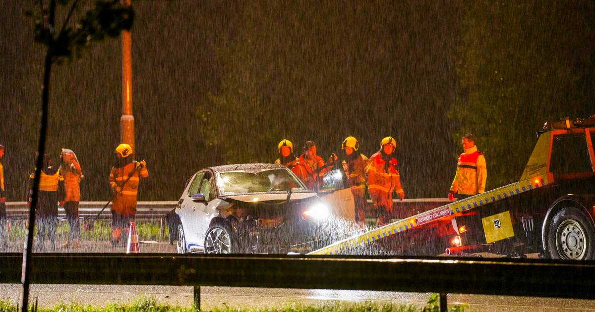 Ongeluk met drie autos op A2, hulpverleners in stromende regen.