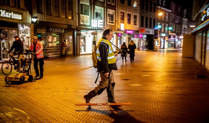 Specialisten lopen met meetapparatuur om archeologisch vooronderzoek te doen naar resten van een oude stadspoort bij de kruising Vrijstraat-Demer.