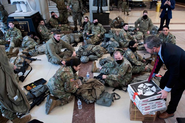 Leden van de Nationale Garde krijgen pizza aangeboden in het Capitool.  Beeld AFP
