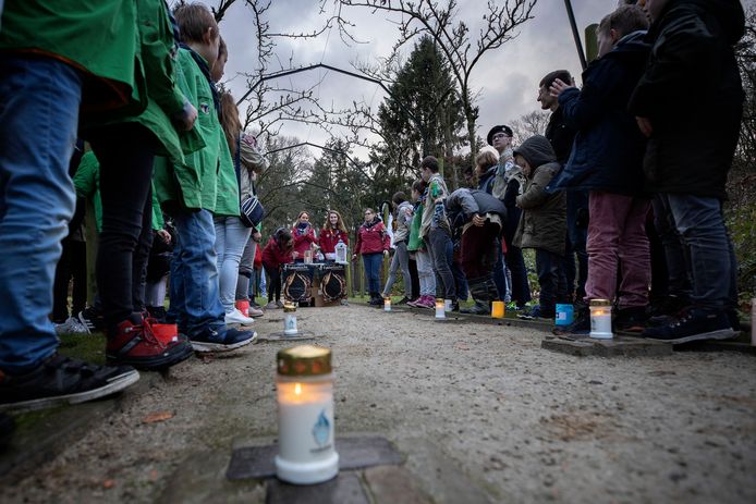 Ontsteken van het vredeslicht op de struikelstenen van de begraafplaats op landgoed De Grote Beek door scouts van de groep Johannes Vianney op 24 december 2019.