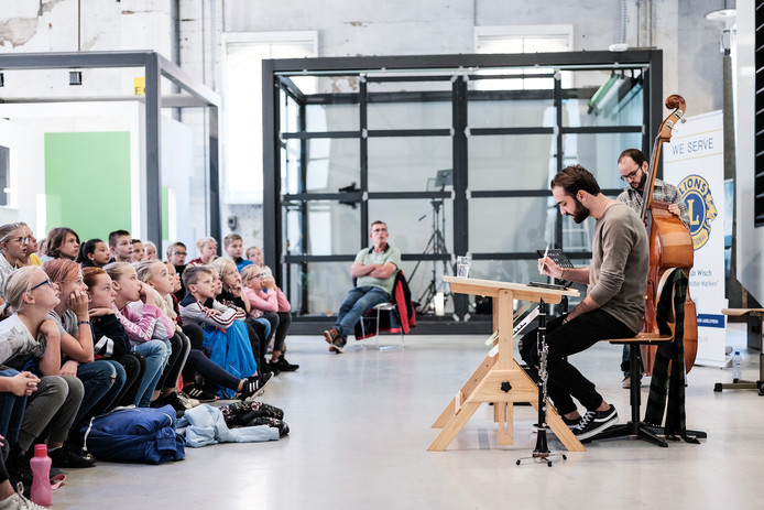 Haidar Habash tijdens een voorstelling voor scholieren, met zijn muzikale begeleiders Bariş Ofluoğlu en Ghaeth Almaghoot.