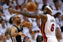 Tony Parker van de Spurs (links) in ggevecht met LeBron James (Miami Heat) om de bal.