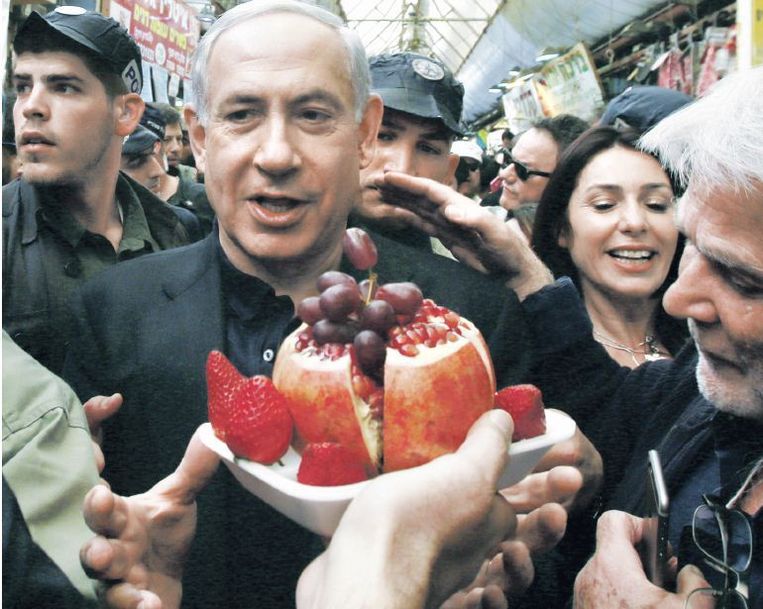 Omringd door veiligheidsmensen begaf Bibi Netanyahu zich vorige week op de beroemde markt van Jeruzalem, Manache Yehuda. Beeld afp