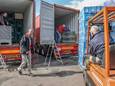Sawasdee-oprichter Hector Loontjens (links voor) helpt mee met het inladen van de containers.