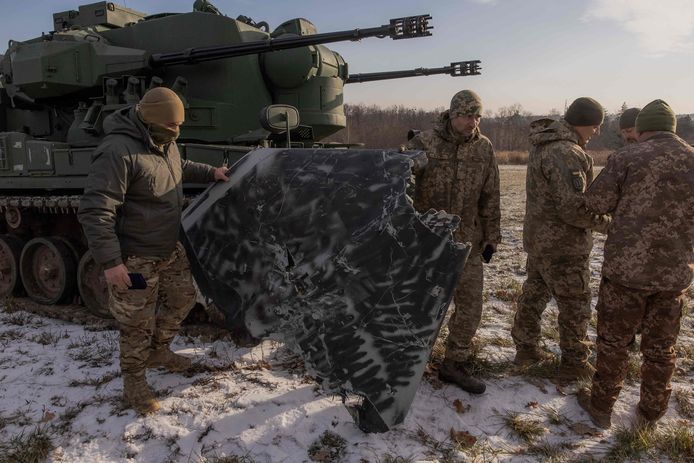 Oekraïense militairen met de resten van een Russische drone die ze uit de lucht gehaald hebben.