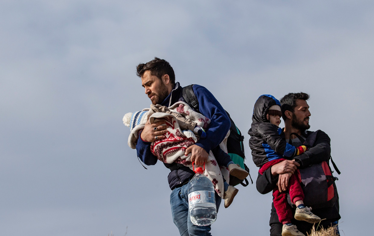 Vaders met hun kinderen proberen bij het West-Turkse Edirne de grens met Griekenland over te steken, begin maart dit jaar. Beeld Erdem Sahin / EPA