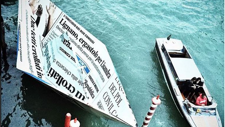Het 'papieren bootje' van kunstenaar Vik Muniz in Venetië. De 'krant' bevat verhalen over het verdrinken van bootvluchtelingen. Beeld Vik Muniz