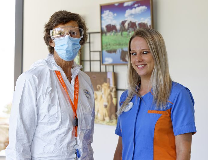 Susan Olijslagers, rechts, in normale kleding. Als er corona heerst op een afdeling dan dragen medewerkers witte pakken, een mondkapje en spatbril. Een mondkapje dragen ze standaard in het verpleegtehuis.