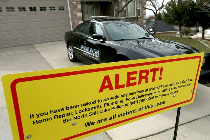 Een bord met een waarschuwing en een politiewagen voor de woning van Walt Gilmore in Salt Lake City. Het hele gezin werd vijftien maanden lang geteisterd door een cyberstalker.