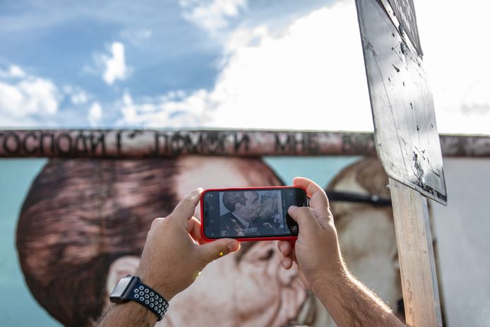 Een toerist neemt een foto van een restant van de Berlijnse Muur aan de East Side Gallery in de Duitse hoofdstad.