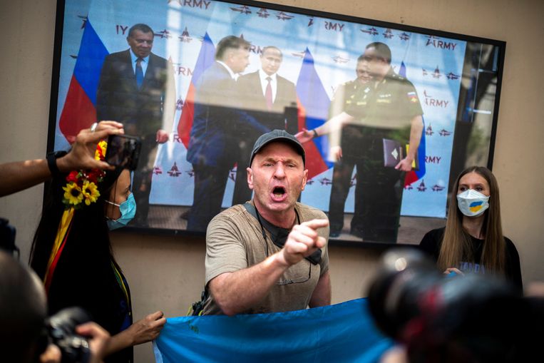 Een Oekraïner in Bangkok reageert woedend op Russische berichtgeving op televisie.  Beeld REUTERS