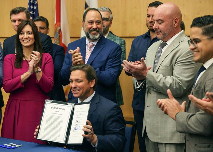 De gouverneur van Florida Ron DeSantis houdt de ondertekende wet omhoog.
