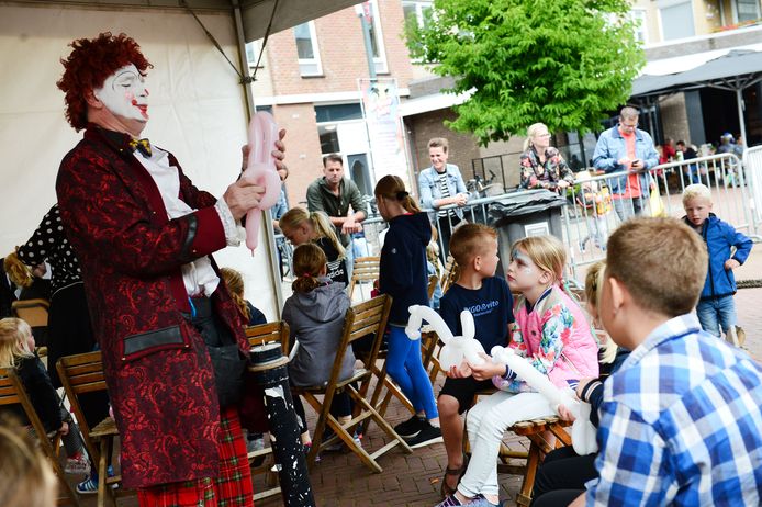 Een clown vermaakt de jeugd met zijn creaties van ballonnen.