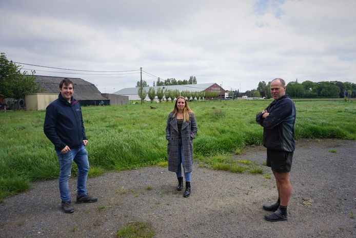 Op de weide van Wim Matthys (rechts) staat nu nog hoog gras, maar straks verrijst hier een grote zomerbar onder de noemer Rock To Bar, zo kondigen Bart Lauwers en Freya Schoolmeester aan.