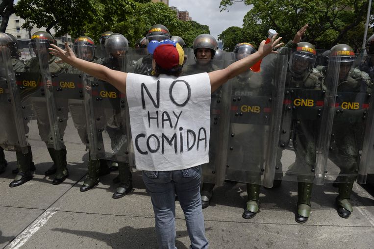 Een vrouw met de tekst 'er is geen eten' protesteert tegen een nieuwe noodmaatregel van president Nicolás Maduro in de Venezolaanse hoofdstad Caracas.  Beeld AFP
