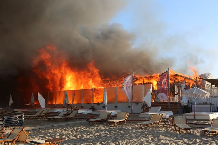 De brandweer laat de strandtent gecontroleerd uitbranden.