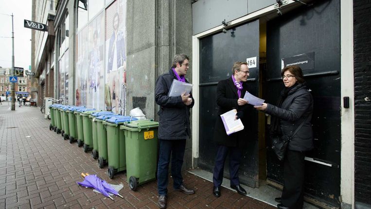 CNV onderhandelaar Martijn den Heijer (L) en CNV-voorzitter Maruice Limmen (M) werven leden bij de personeelsingang van de V&D aan de Kalverstraat. Beeld anp