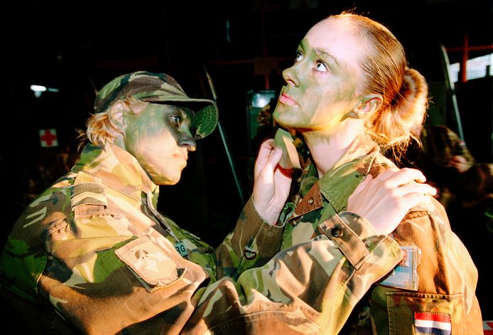 Militairen schminken elkaar met camouflage-schmink in Ermelo.