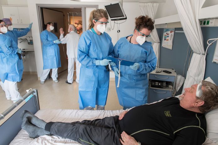 Unitmanager Antonie Bergers (r) aan het bed van patiënt Johan van Ingen ( 67 ) op de corona-afdeling. Naast Bergers staat haar collega Eugenie Verschoor.