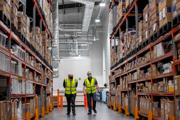 Boris Johson op werkbezoek in het magazijn van Oxford Biomedica, producent van het AstraZenecavaccin. Beeld AFP