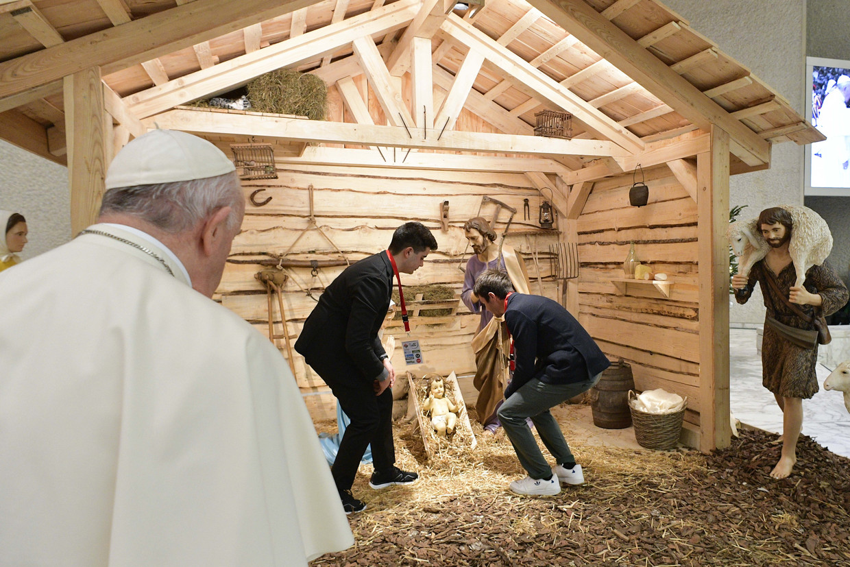 Paus Franciscus kijkt toe hoe in het Vaticaan een kerststalletje ingericht wordt. Beeld Photo News