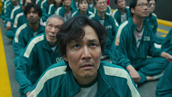 Seong Gi-hun, het hoofdpersonage van de populaire Netflix-serie Squid Game, kijkt met zijn medespelers naar een dodelijk potje touwtrekken dat ook hem te wachten staat.