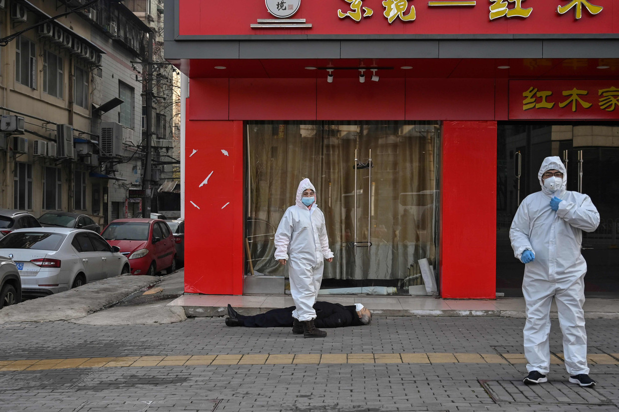 Een man op straat in Wuhan die is gestorven in de buurt van het ziekenhuis. Beeld AFP