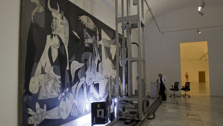 Een technicus werkt aan Pablo Picasso's 'Guernica' schilderij in het Reina Sofia Museum in Madrid. Beeld ap
