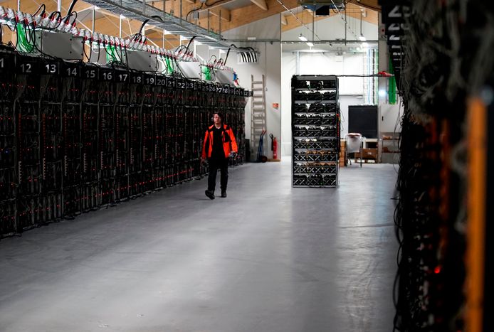 Een medewerker loopt rond in de hal van een IJslandse bitcoinfabriek.