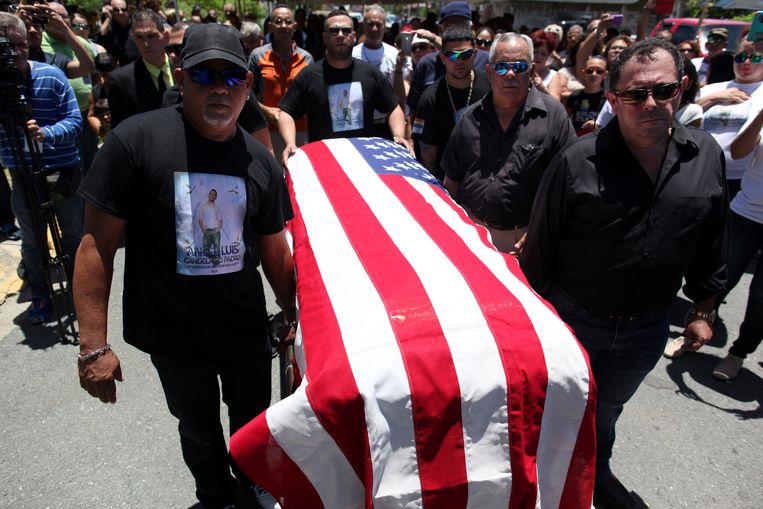 Familieleden en vrienden dragen het lichaam van Angel Candelario naar zijn begraafplaats. Beeld reuters