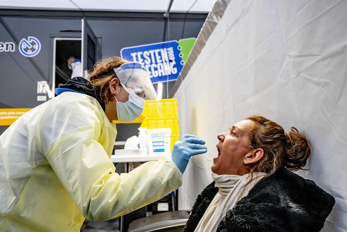 Een medewerker van een commercieel testbedrijf voert een coronatest uit bij een commercieel testbedrijf.