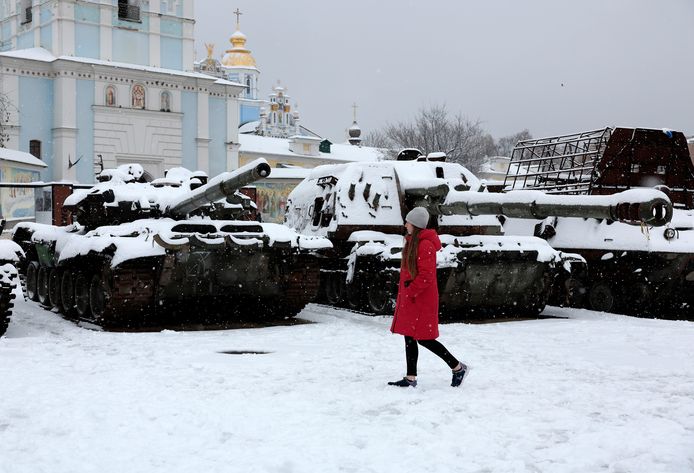 Een vrouw wandelt voorbij vernietigde Russische tanks in de Oekraïense hoofdstad Kiev.
