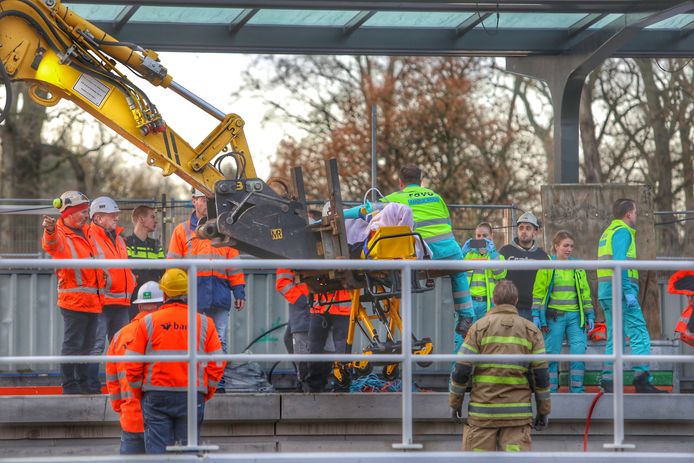 De gevallen bouwvakker is met een kraan naar de uitgang van het perron gebracht.