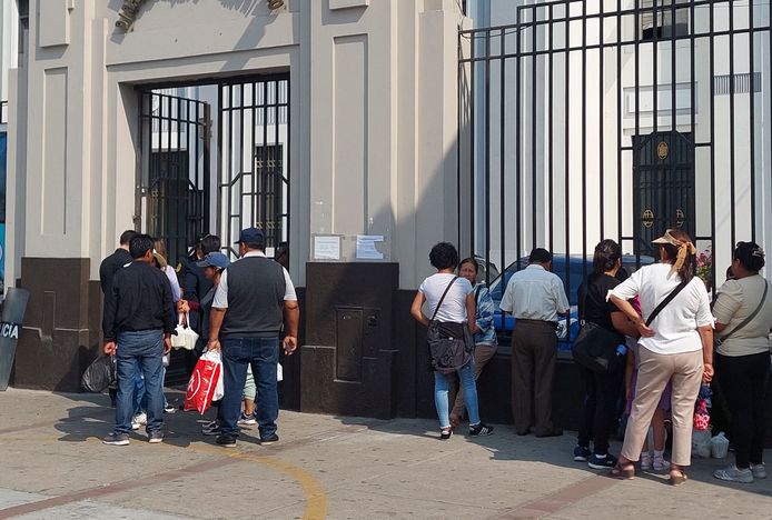 Familieleden van de gearresteerde demonstranten wachten op informatie bij een politiebureau in Lima.