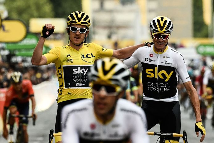 TOPSHOT - Tour de France winner Great Britain's Geraint Thomas (L) wearing the overall leader's yellow jersey and classification third-placed Great Britain's Christopher Froome (C) react as they cross the fisnish line of 21st and last stage of the 105th edition of the Tour de France cycling race between Houilles and Paris Champs-Elysees, on July 29, 2018.  / AFP PHOTO / Philippe LOPEZ