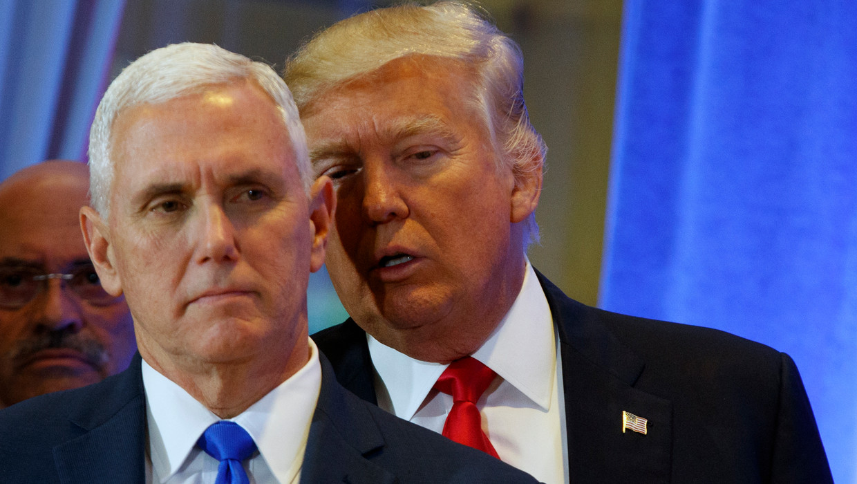 Donald Trump praat met de aanstaande vicepresident Mike Pence tijdens de persconferentie. Beeld AP