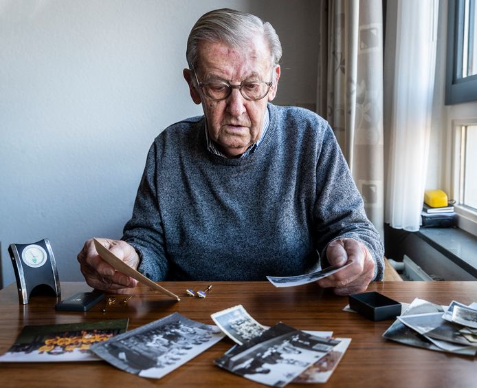 Theo Lambert (90) met foto's en speldjes die herinneren aan tachtig jaar voetbal.