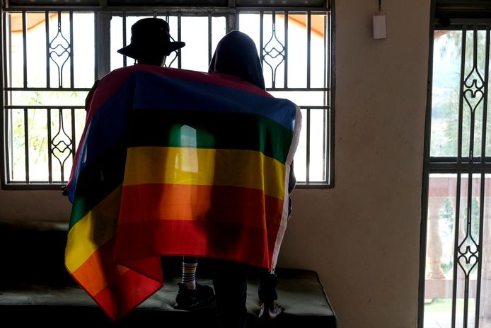 Een Oegandees koppel met de regenboogvlag.