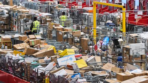 Onze man in Brussel X, waar elk uur 20.000 dozen van de band vliegen: zelfs CEO draagt op zaterdag mee pakjes rond
