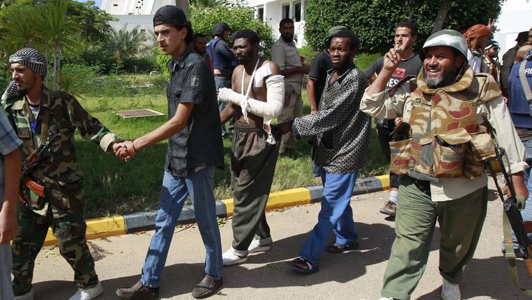 Strijders van het nieuwe bewind in Libië begeleiden gevangenen in Sirte. Beeld reuters