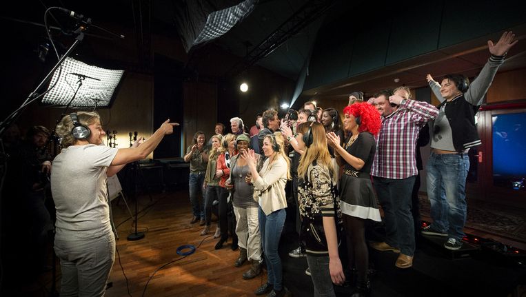 Een groep BN'ers met op de voorgrond John Ewbank tijdens het opnemen van het Koningslied. Beeld anp