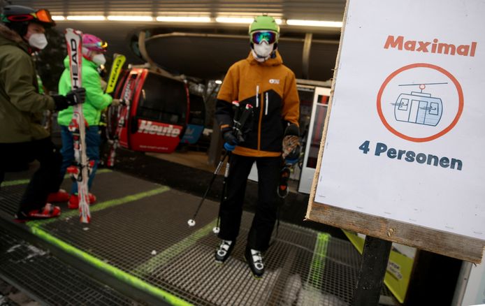 Skiërs met mondmaskers aan een kabellift in Semmering.