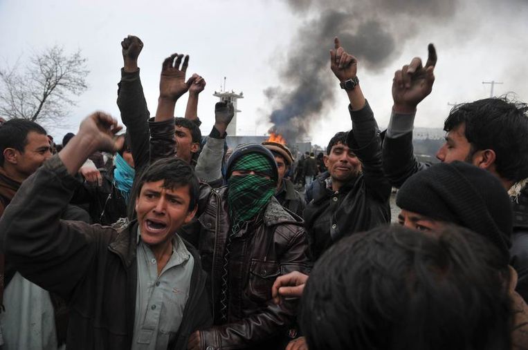 Afghaanse demonstranten schreeuwen anti-Amerikaanse slogans aan de poort van de vliegbasis in Bagram. Beeld afp