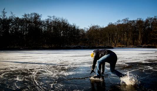 Een schaatser zakt door het ijs