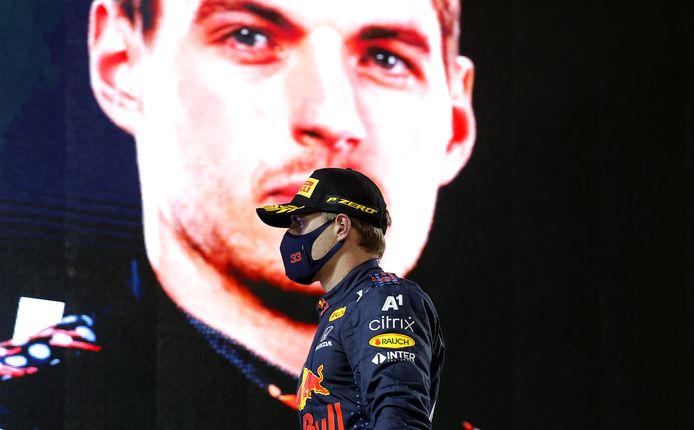 Max Verstappen na de podiumceremonie, met achter hem een levensgrote afbeelding van zichzelf.