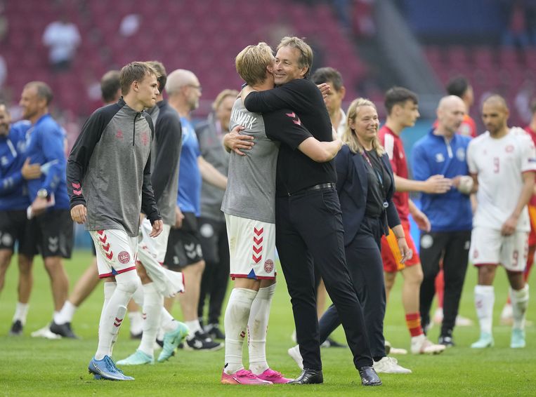 Coach Kasper Hjulmand van Denemarken knuffelt een speler na de winst in de achtste finales van het EK op Wales. Beeld EPA