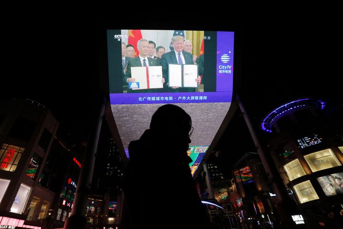 Een groot scherm aan een shoppingcenter toont hoe de leiders van de VS en China poseren na de ondertekening van het voorlopige handelsakkoord.