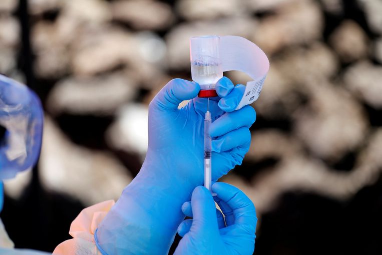 Een verpleegkundige doet het ebola-vaccin in een injectiespuit. Beeld Reuters