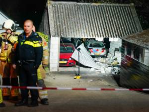 Politieauto vliegt van dijk en komt in schuur terecht na achtervolging